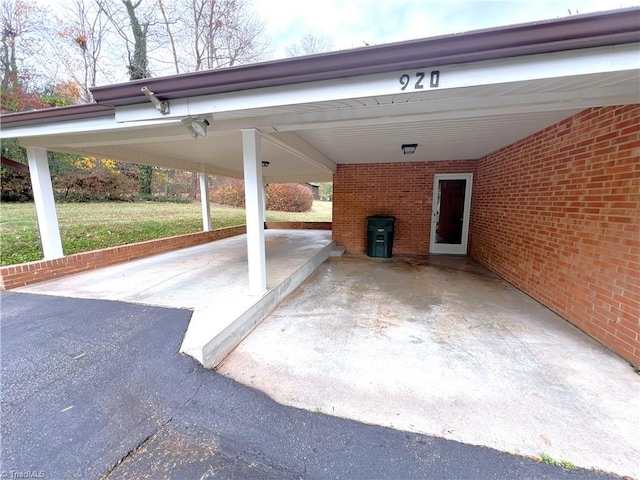 view of parking / parking lot featuring a yard and a carport