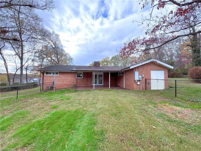 rear view of house with a patio and a lawn