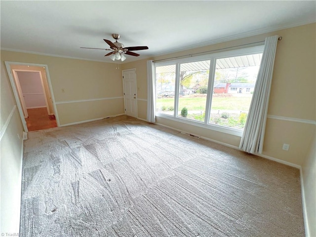 carpeted empty room with ceiling fan and ornamental molding