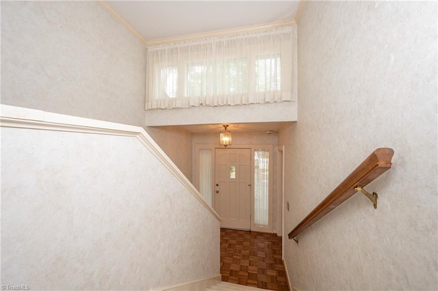 foyer entrance with stairs, a high ceiling, plenty of natural light, and ornamental molding