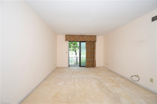 carpeted spare room featuring visible vents and baseboards