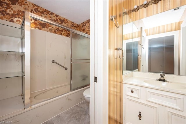 bathroom featuring vanity, toilet, marble finish floor, wallpapered walls, and combined bath / shower with glass door