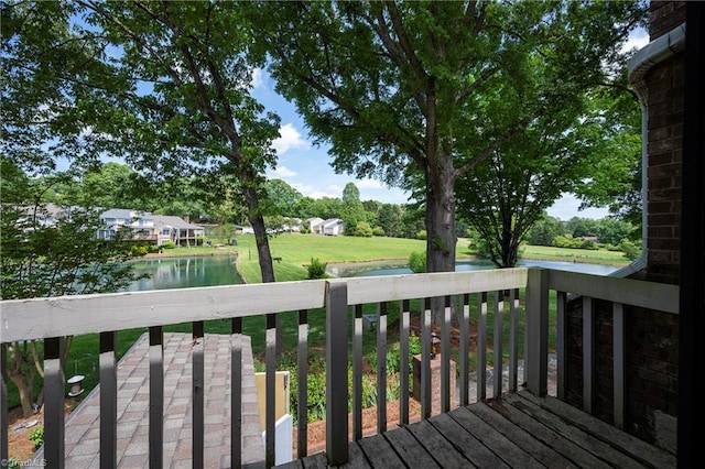 wooden deck featuring a yard and a water view