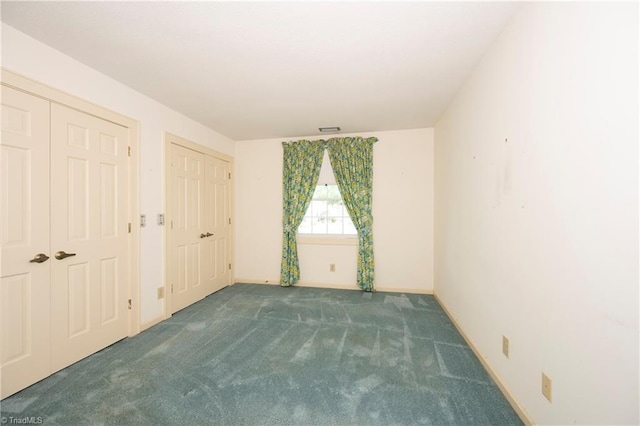 unfurnished bedroom featuring carpet floors, baseboards, and visible vents