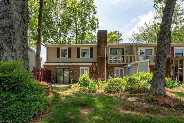 back of property featuring brick siding and a chimney