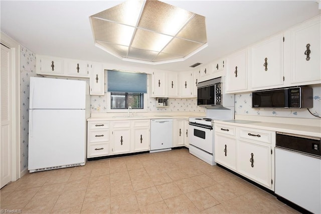 kitchen with a sink, white cabinets, white appliances, and light countertops
