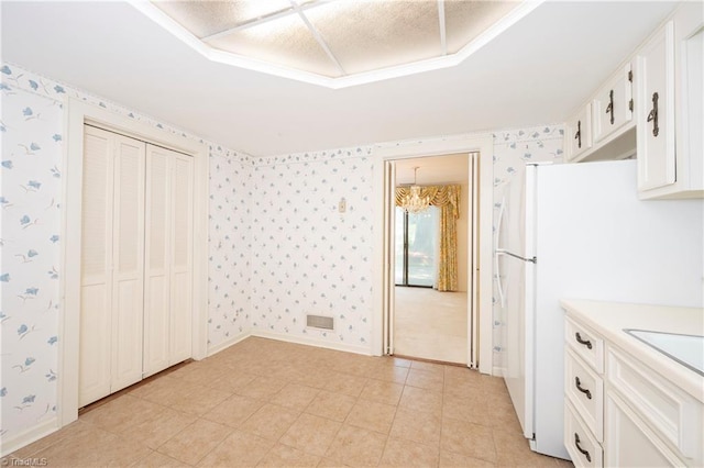 interior space featuring light countertops, wallpapered walls, and a chandelier