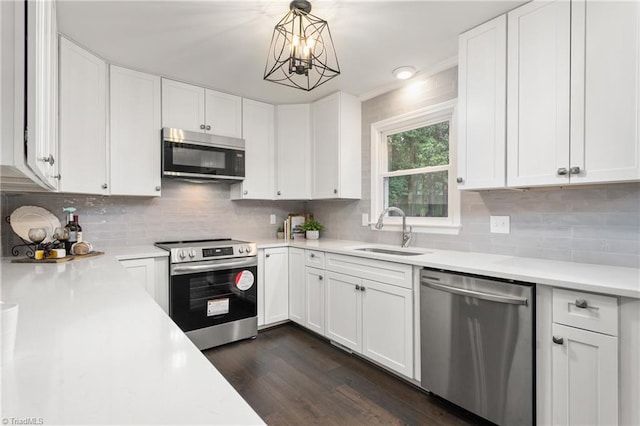 4105 Oak Hollow Dr, High Point, NC 27265 - kitchen with stainless steel appliances, light countertops, dark wood-style flooring, white cabinets, and decorative backsplash