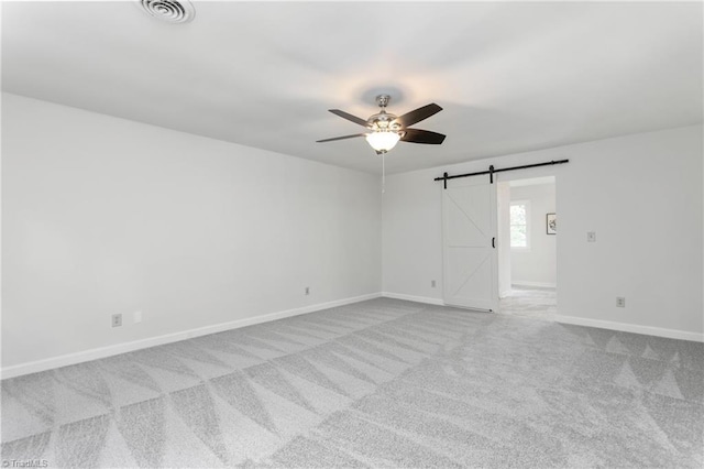 4105 Oak Hollow Dr, High Point, NC 27265 - empty room featuring a barn door, ceiling fan, and carpet floors