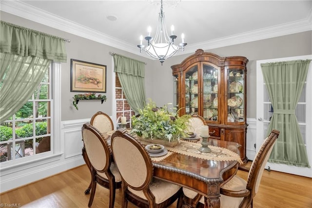 7672 Crossing Ridge Dr, Belews Creek, NC 27009 - dining space featuring a chandelier, light wood-style floors, ornamental molding, wainscoting, and a decorative wall