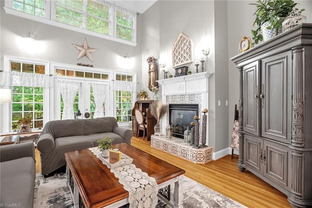 7672 Crossing Ridge Dr, Belews Creek, NC 27009 - living room featuring a towering ceiling, light wood-type flooring, and a tile fireplace