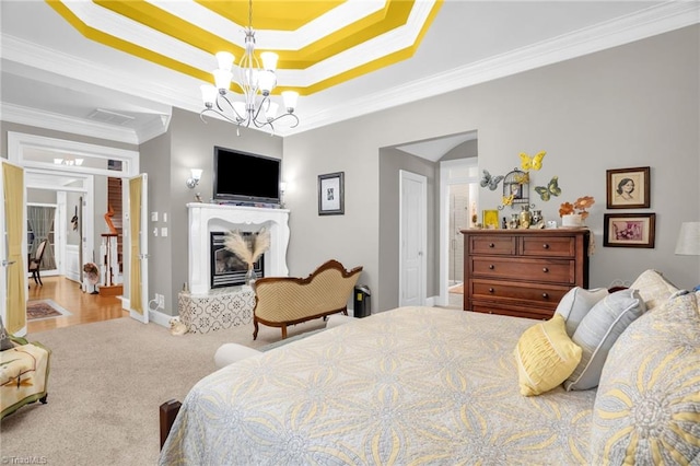 7672 Crossing Ridge Dr, Belews Creek, NC 27009 - carpeted bedroom featuring crown molding, a chandelier, a glass covered fireplace, and a tray ceiling