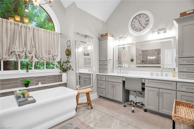 7672 Crossing Ridge Dr, Belews Creek, NC 27009 - full bath with vanity, a soaking tub, vaulted ceiling, tile patterned flooring, and a tile shower