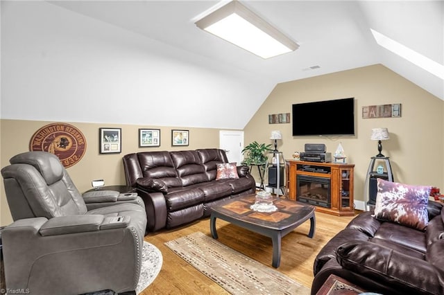7672 Crossing Ridge Dr, Belews Creek, NC 27009 - living area featuring light wood finished floors, vaulted ceiling, and a skylight