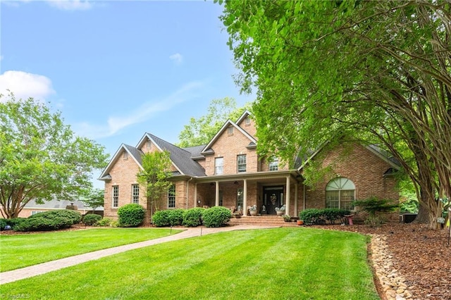 7672 Crossing Ridge Dr, Belews Creek, NC 27009 - view of front facade featuring brick siding, a porch, and a front yard