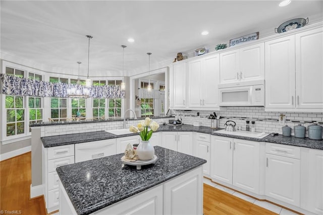 7672 Crossing Ridge Dr, Belews Creek, NC 27009 - kitchen with white appliances, a peninsula, a center island, white cabinetry, and recessed lighting