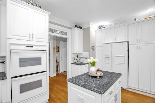7672 Crossing Ridge Dr, Belews Creek, NC 27009 - kitchen featuring white appliances, white cabinetry, a kitchen island, tasteful backsplash, and light wood-style floors
