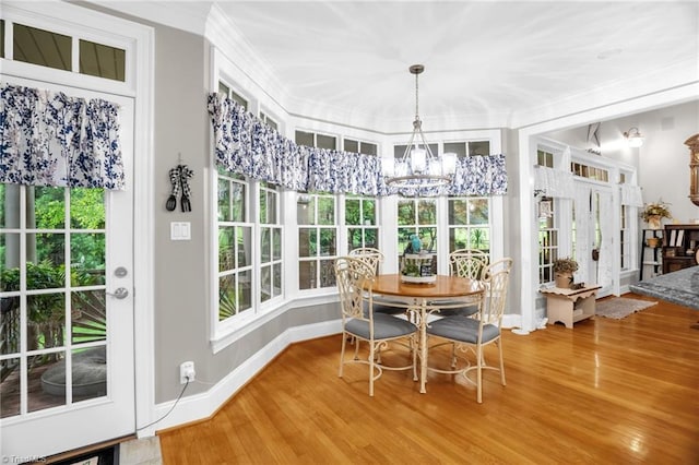 7672 Crossing Ridge Dr, Belews Creek, NC 27009 - dining space with ornamental molding, wood finished floors, a chandelier, and healthy amount of natural light