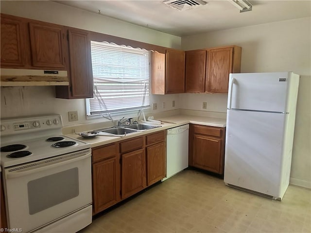 3815 Sheridan Rd, Greensboro, NC 27455 - kitchen with white appliances, under cabinet range hood, a sink, light countertops, and brown cabinets