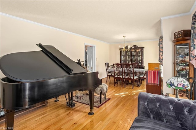 living area with hardwood / wood-style floors, crown molding, and a chandelier