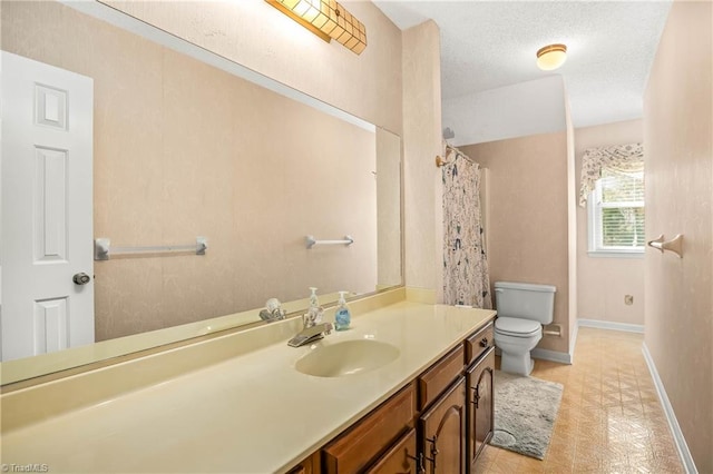 bathroom featuring vanity, a textured ceiling, and toilet