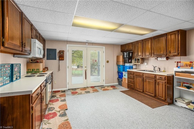 kitchen featuring french doors, sink, stainless steel electric stove, a paneled ceiling, and light carpet