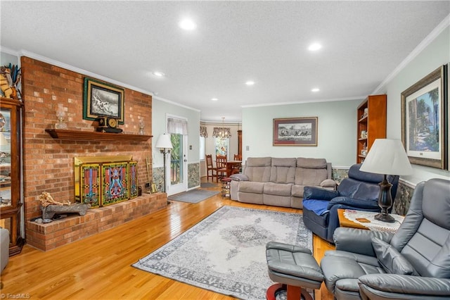 living room with crown molding, a fireplace, a textured ceiling, and hardwood / wood-style flooring