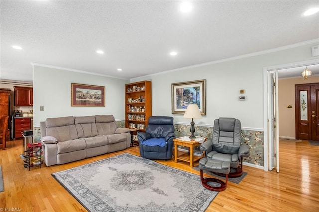 living room featuring ornamental molding, a textured ceiling, and light hardwood / wood-style flooring