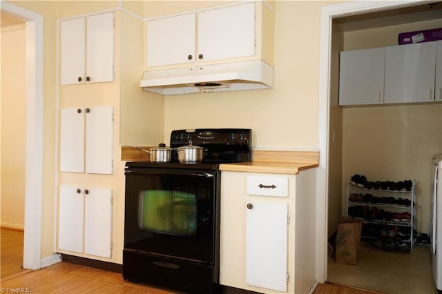 kitchen featuring light wood-type flooring, electric range, and white cabinetry