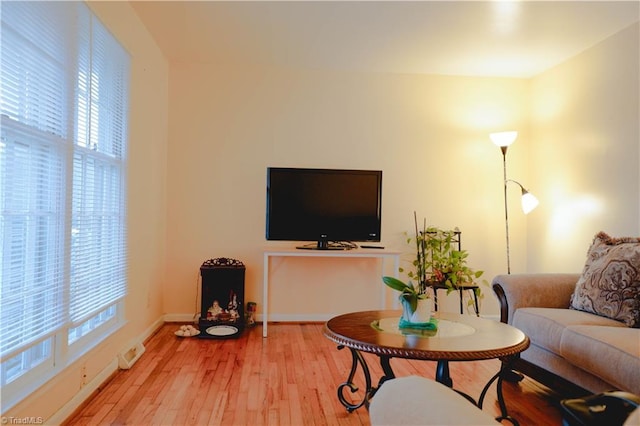 living room with a wealth of natural light and light hardwood / wood-style flooring