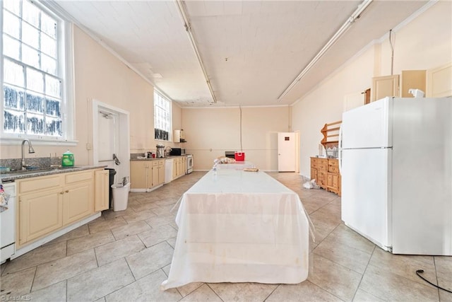 kitchen with white appliances, sink, crown molding, light tile patterned flooring, and cream cabinets