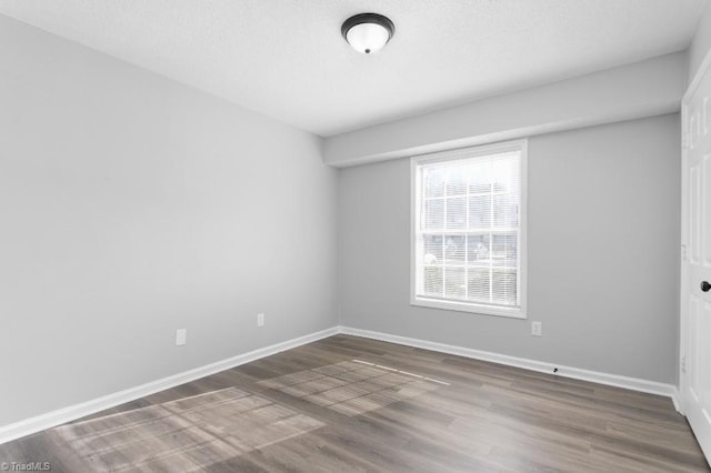 empty room with dark hardwood / wood-style flooring