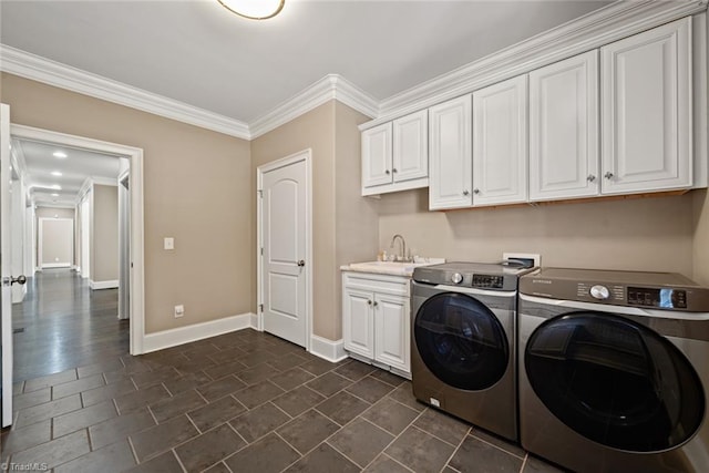 laundry area with cabinets, washing machine and clothes dryer, crown molding, and sink