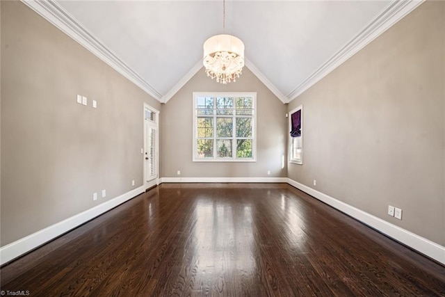 spare room featuring dark wood-type flooring, lofted ceiling, ornamental molding, and a chandelier