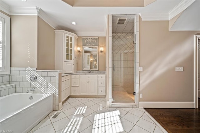 bathroom featuring independent shower and bath, ornamental molding, tile patterned floors, and vanity