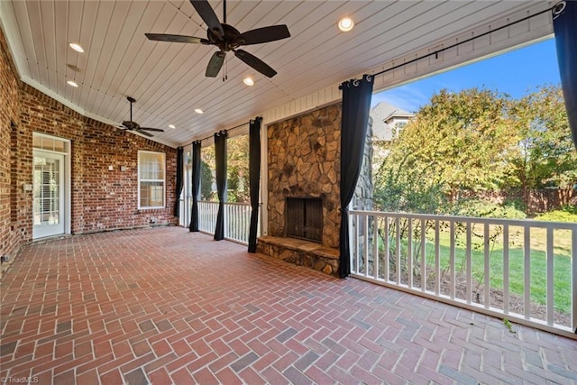 view of patio with ceiling fan and a fireplace