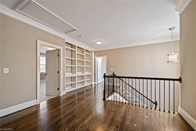 empty room featuring crown molding, a chandelier, and dark hardwood / wood-style flooring