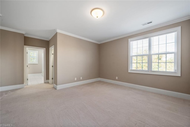 spare room featuring light colored carpet, a healthy amount of sunlight, and ornamental molding