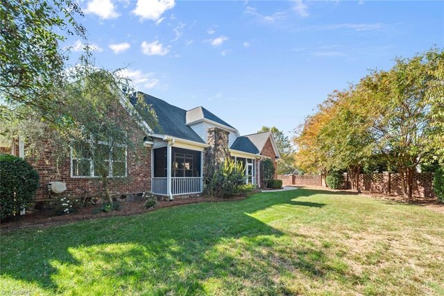 view of front of home with a front yard and a sunroom