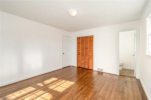 spare room with hardwood / wood-style floors and a textured ceiling