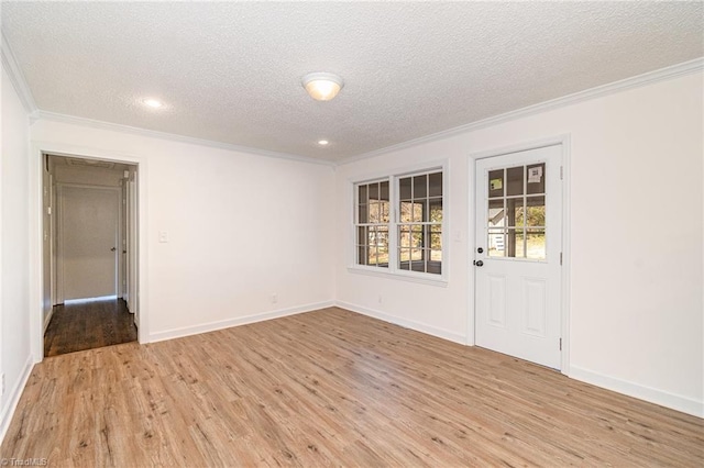 spare room featuring a textured ceiling, light wood-type flooring, and ornamental molding