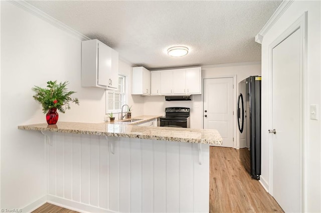 kitchen featuring black appliances, white cabinets, sink, a textured ceiling, and kitchen peninsula