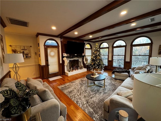 living room featuring beamed ceiling and light hardwood / wood-style floors