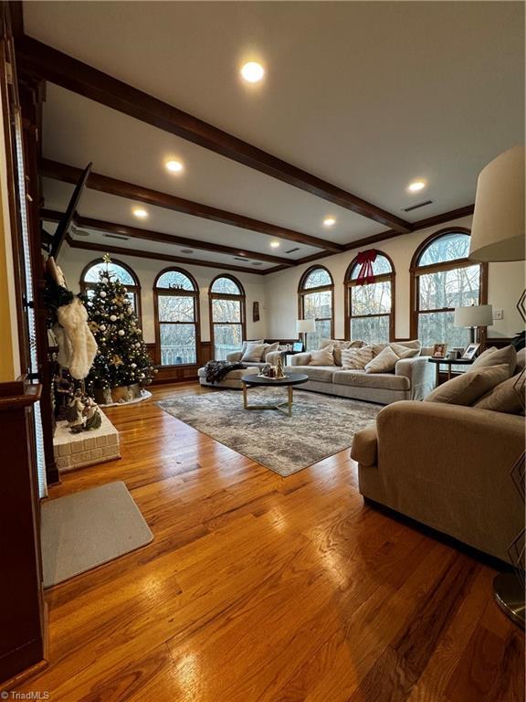 living room with visible vents, wood finished floors, beam ceiling, and recessed lighting