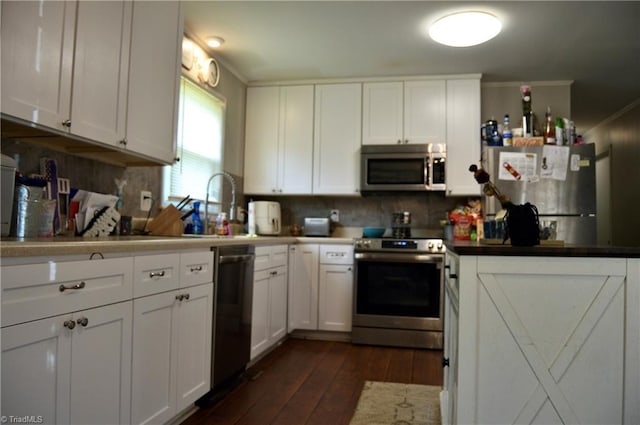 kitchen featuring stainless steel appliances, dark wood-type flooring, white cabinetry, backsplash, and crown molding