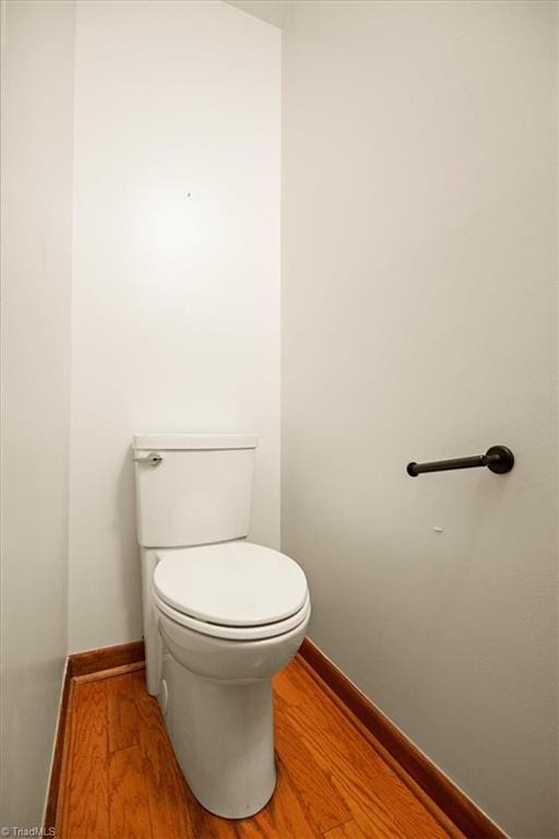 bathroom with toilet and hardwood / wood-style flooring