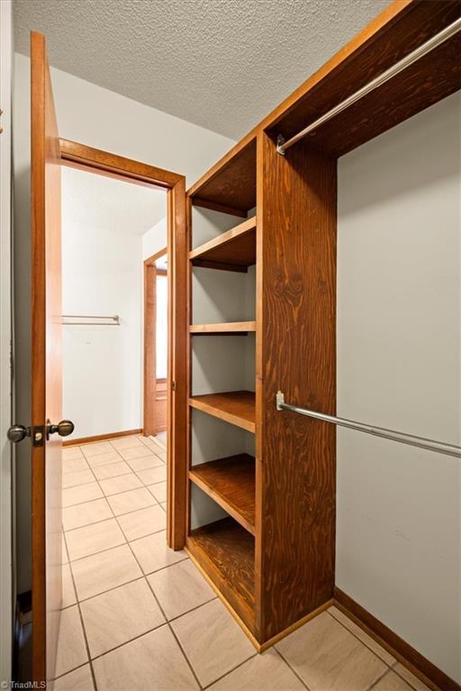 walk in closet with light tile patterned floors