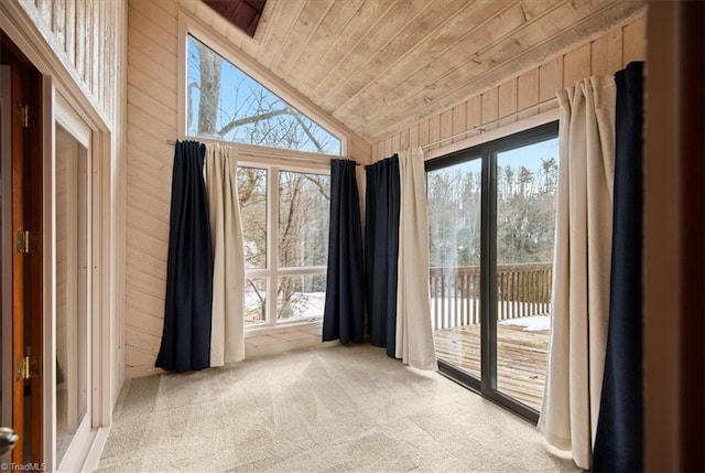 doorway to outside with lofted ceiling, wood ceiling, a wealth of natural light, and wood walls