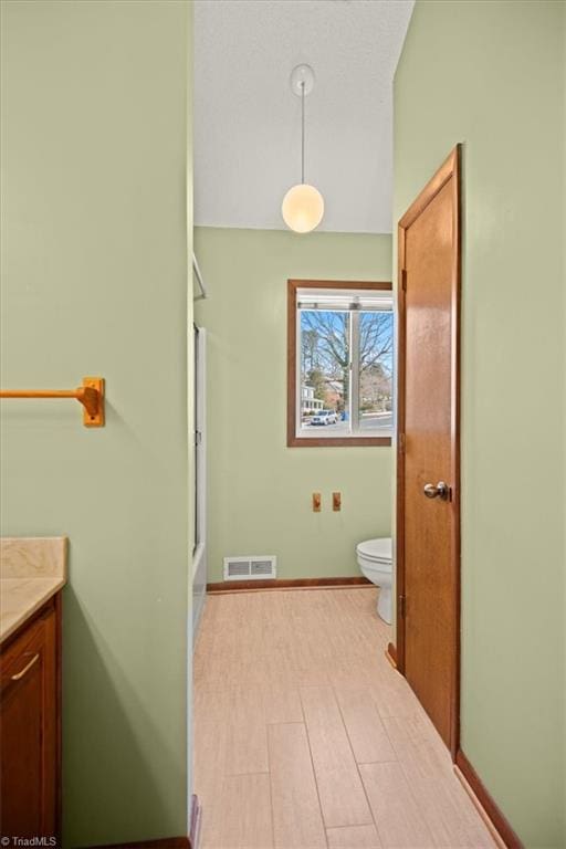 full bathroom with toilet, bath / shower combo with glass door, hardwood / wood-style floors, and vanity