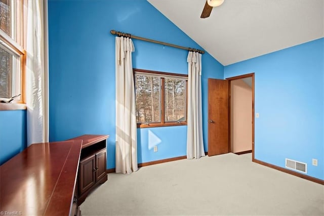 unfurnished bedroom with ceiling fan, vaulted ceiling, and light carpet